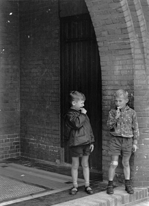 361156 Afbeelding van twee jongetjes in de portiek van een onbekend gebouw, vermoedelijke te Utrecht.